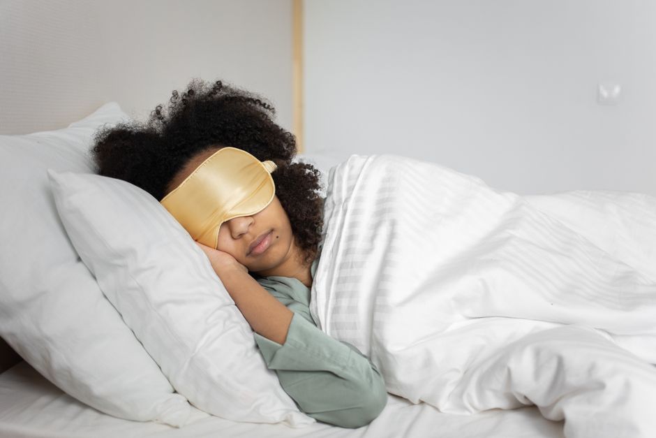 Contoured sleep mask worn while sleeping on the side